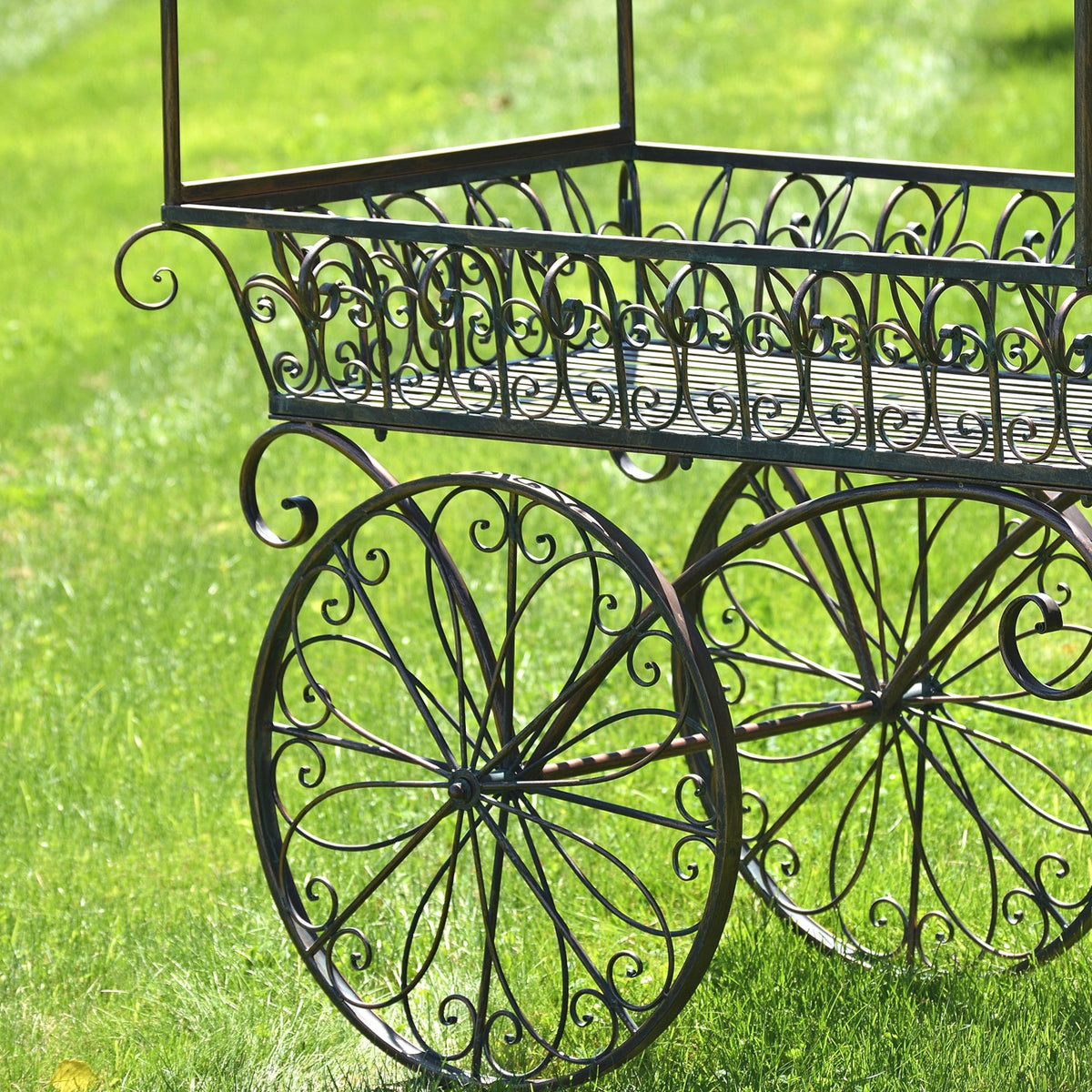 Close view of the cart’s scrolling iron basket and two large decorative wheels.