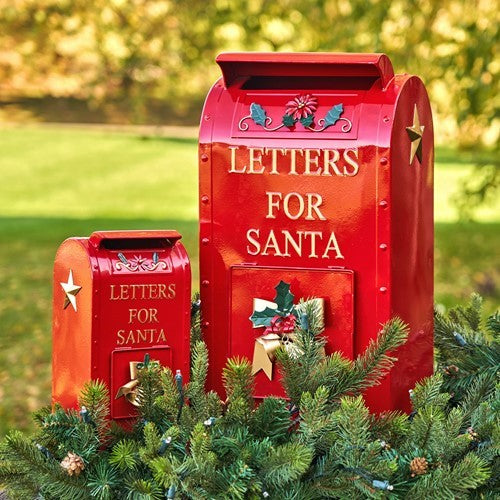 Pair of red Santa mailboxes among evergreen branches, shown from the front outdoors