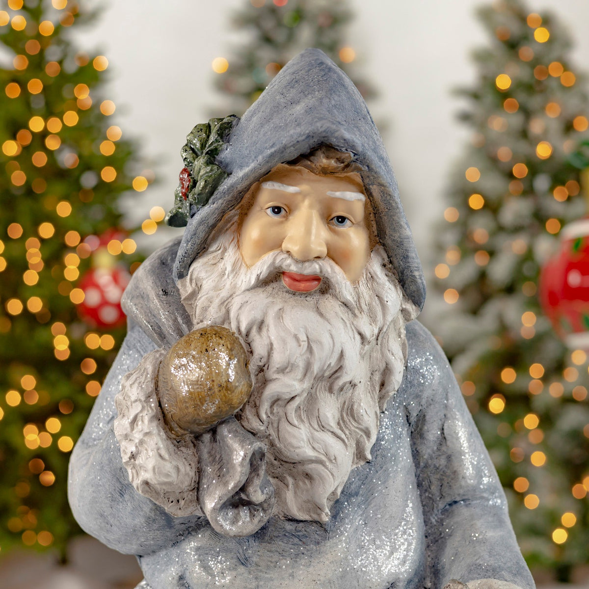 Close-up of hooded Santa's face, white beard and gold-colored toy bag