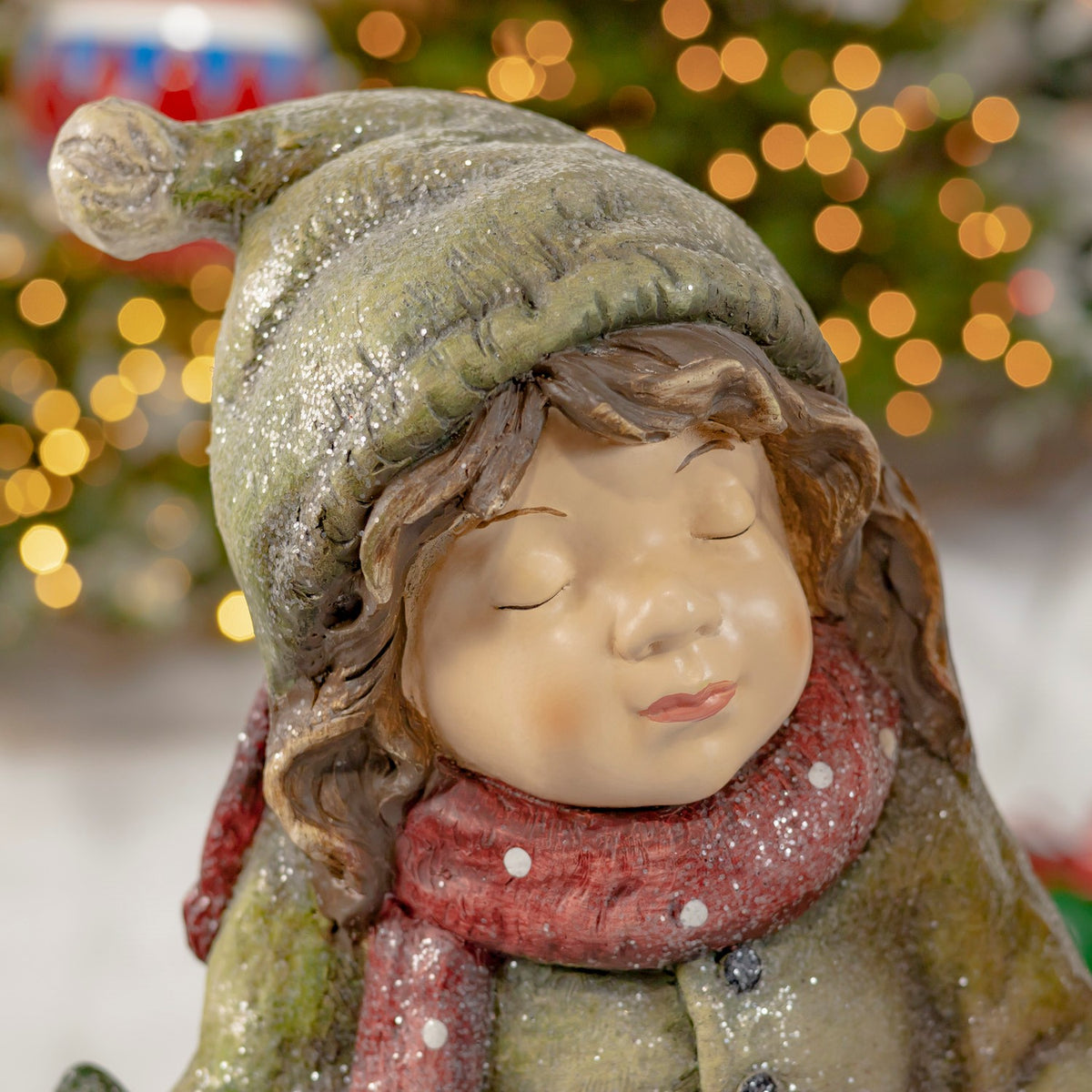 Close-up of the girl figurine in a green hat and red scarf