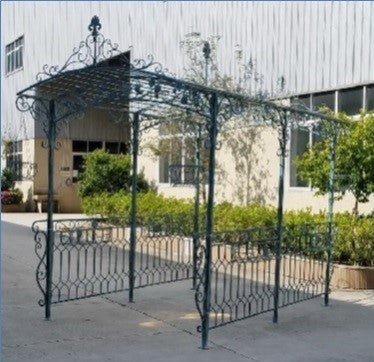 Dark blue iron gazebo with decorative fencing shown at an angle beside a building