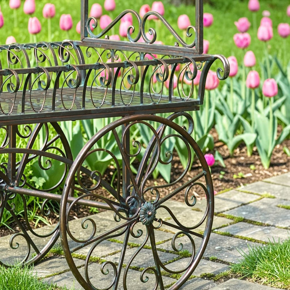 Close view of the cart’s large decorative spoked wheel beneath its curled iron tray rails.