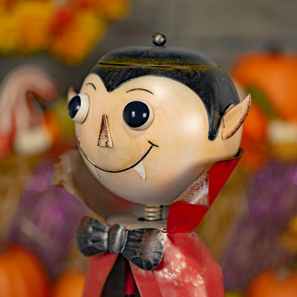Close-up angled view of the vampire figurine's face, black hair, and red cape