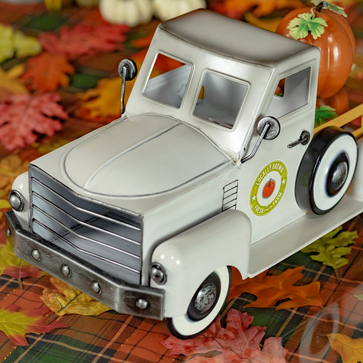 Close view of the truck’s front grille, rounded headlights, cab, and side door emblem.