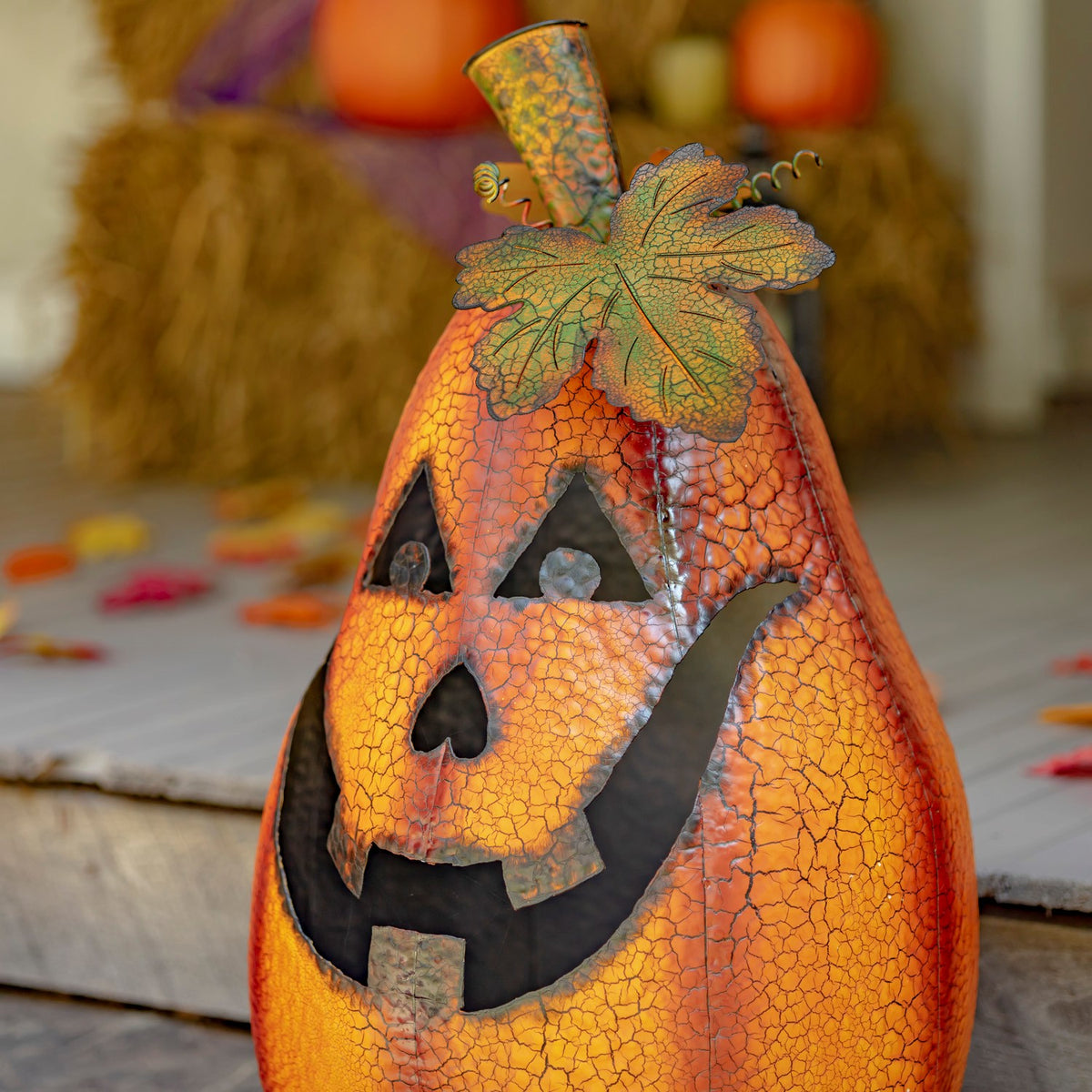 Close angled view of the orange metal jack-o'-lantern's carved face