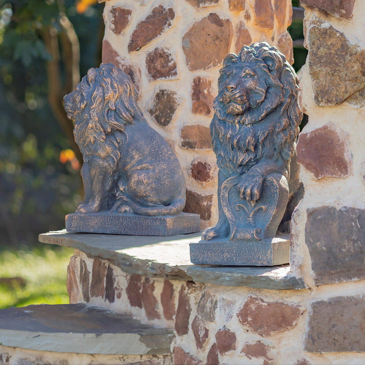 Two lion statues sit on a stone ledge, showing their profiles and carved manes.