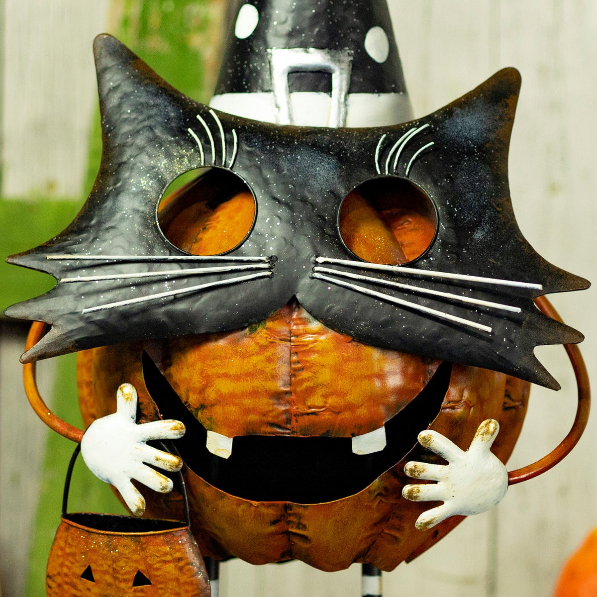 Close-up of the black cat face and orange pumpkin body on the Halloween figurine