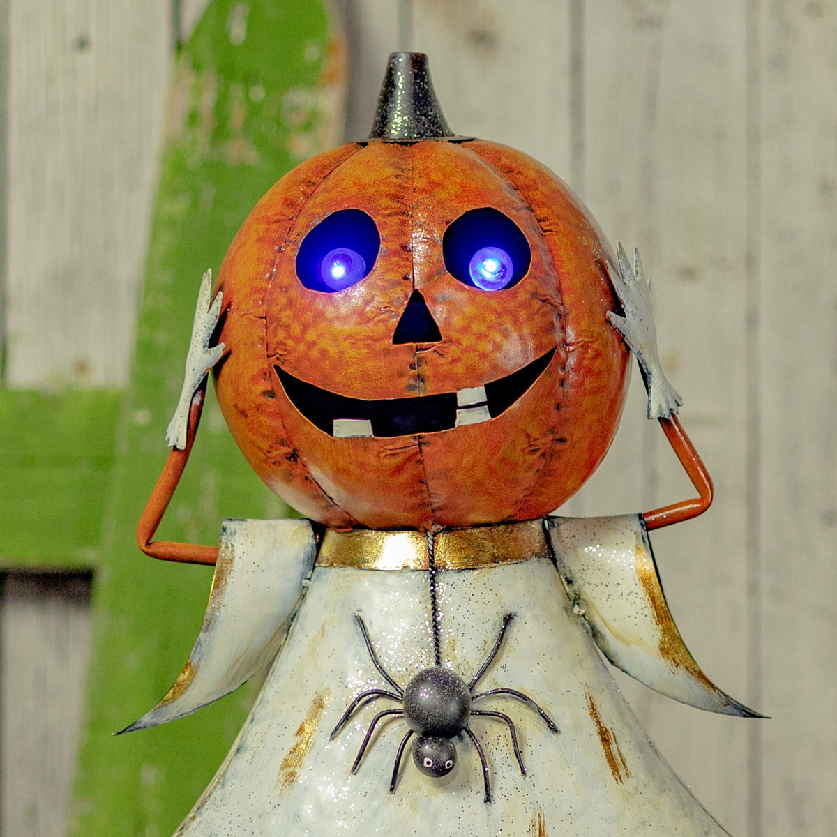 Close view of the orange jack-o'-lantern head and white dress with purple LED eyes