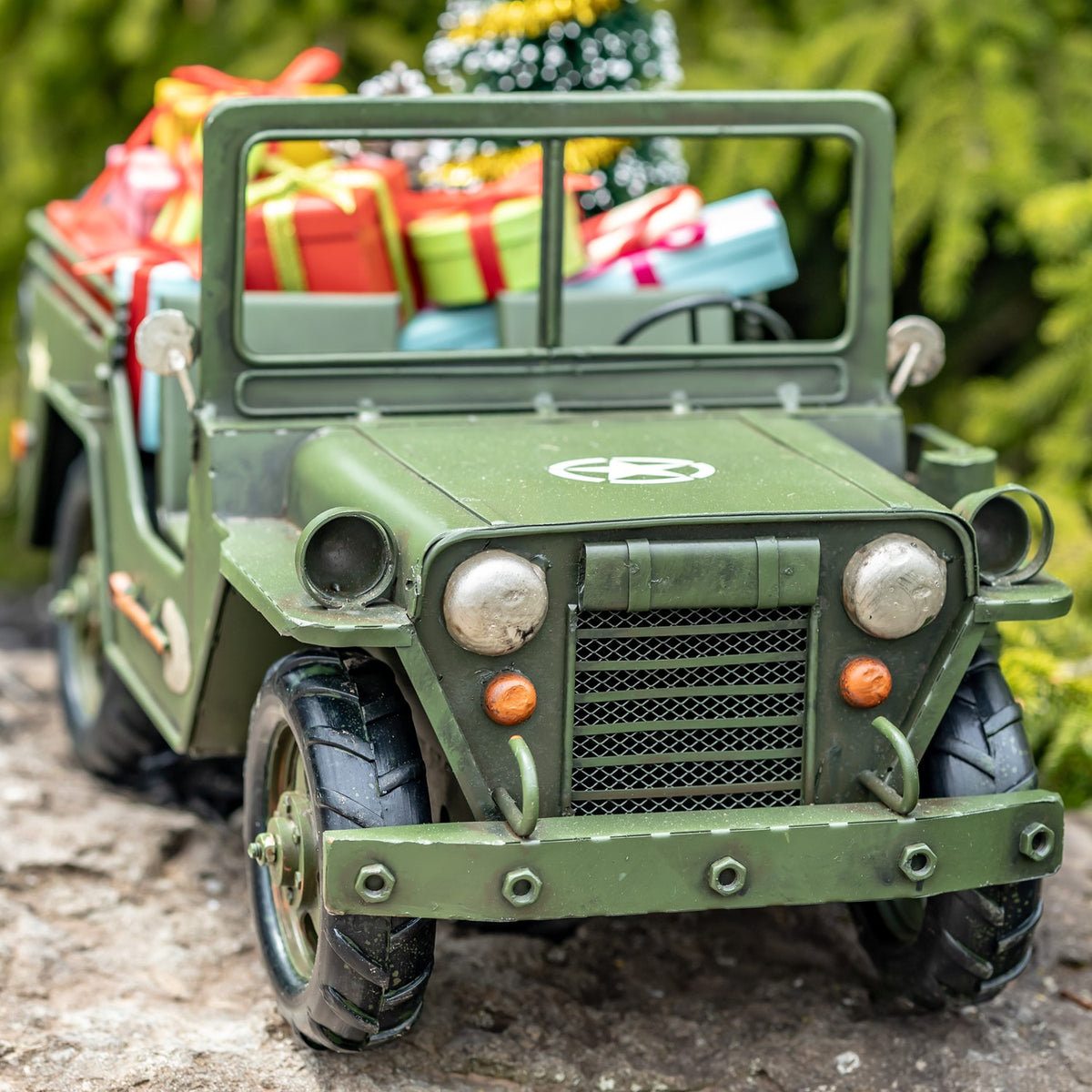 Army-green military vehicle with gifts, close front view of headlights and grille