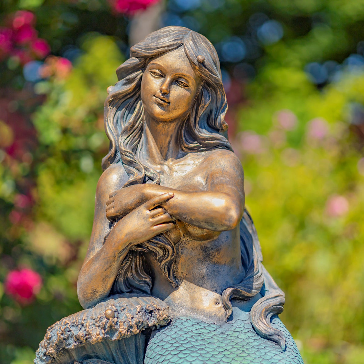 Closer view of the mermaid’s face, flowing hair, crossed arms, and the top of her scaled tail.
