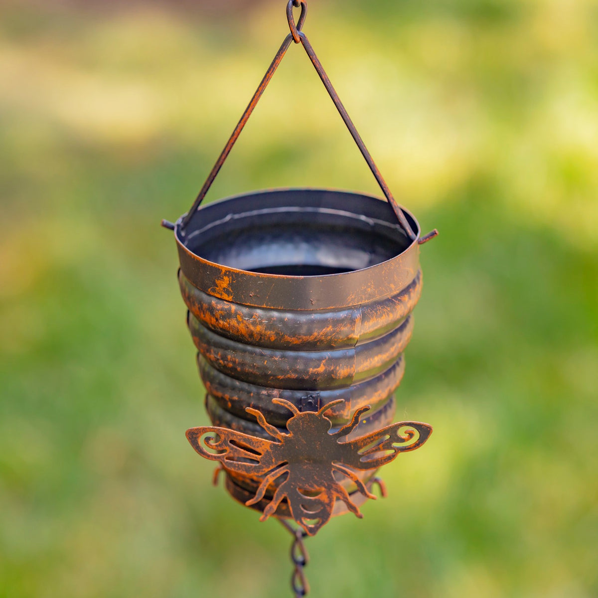 Close view of an antique bronze bucket hive cup with a bumble bee accent