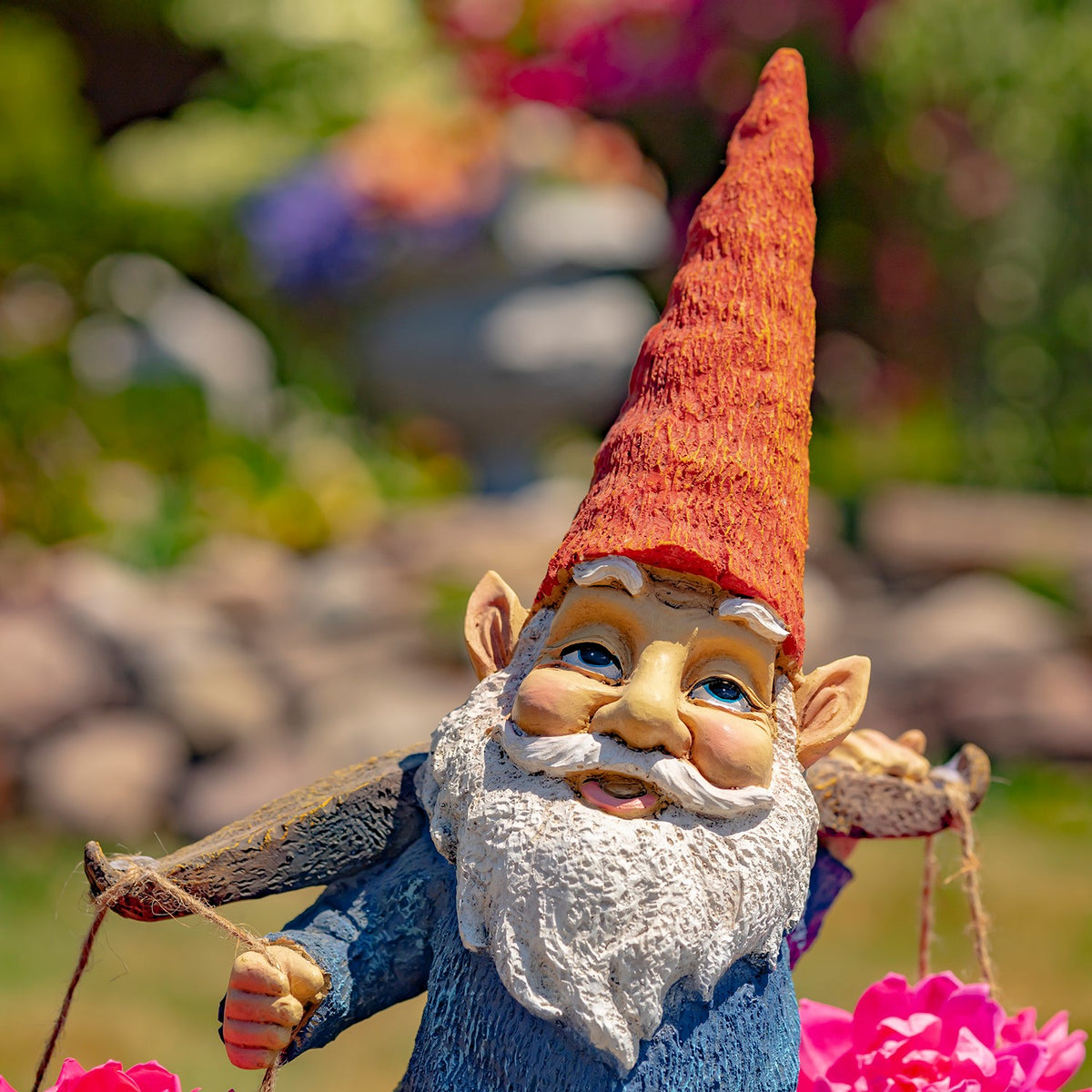 Close view of the gnome’s tall orange hat, smiling face, white beard, and outstretched arms.