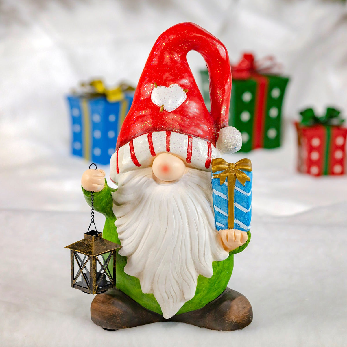 Green-bodied gnome with a red hat holding a gift and hanging lantern