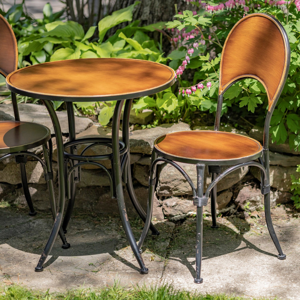 Closer view of the round copper table and one matching chair outdoors