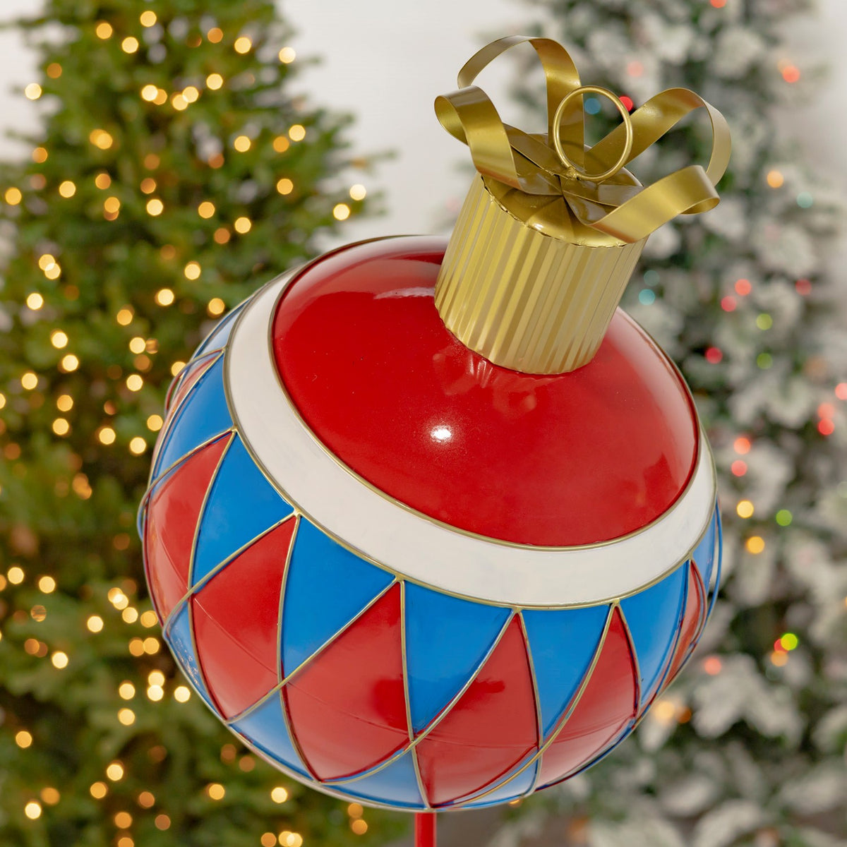 Close view of the ornament’s glossy red top, gold cap, and red-and-blue diamond pattern.
