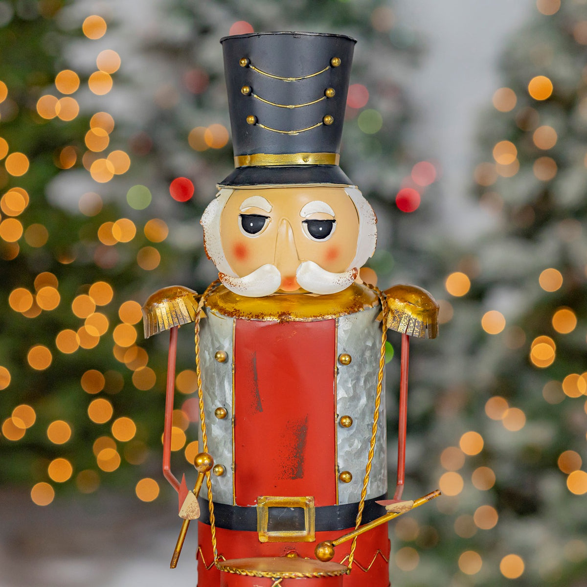 Close front view of the nutcracker's painted face, hat, drum, and uniform