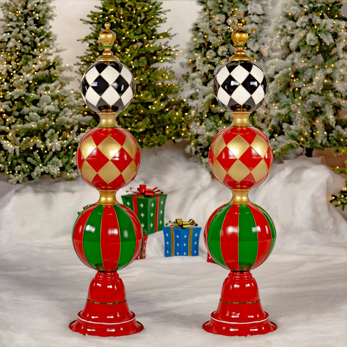 Two matching red-based decorative towers with black, red, and green patterned spheres stand side by side.