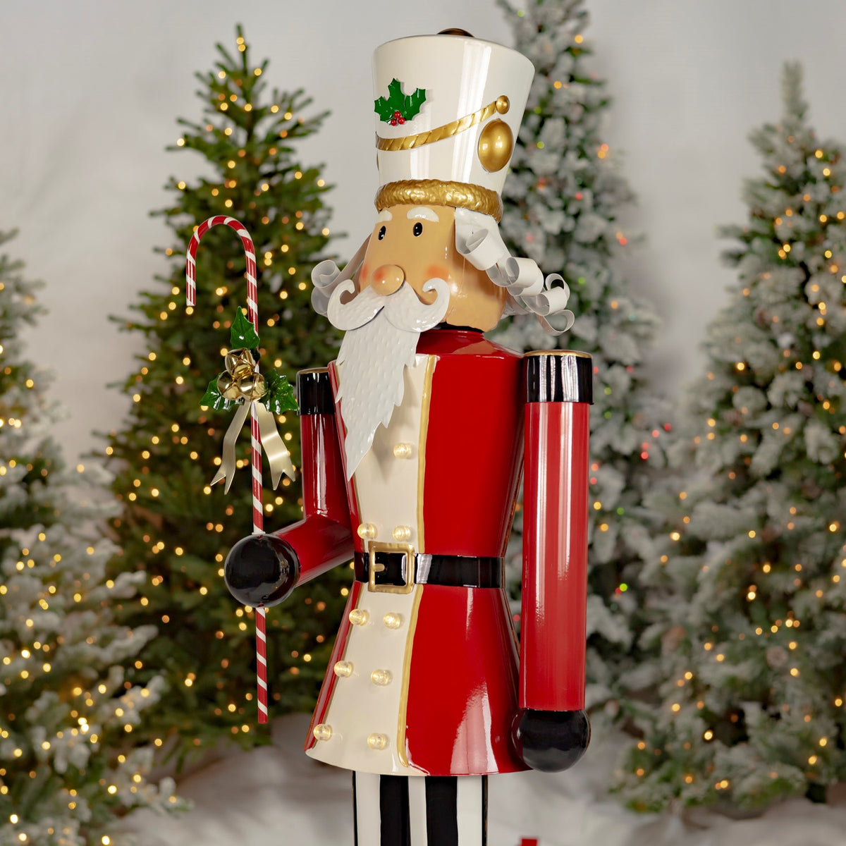 Nutcracker shown at an angle, with a red coat, white beard, and candy cane ornament.