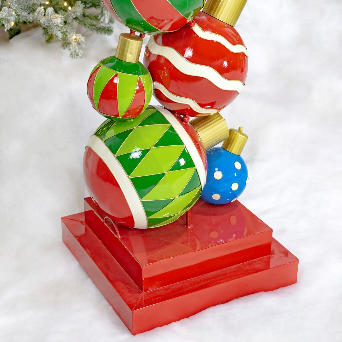 Close view of stacked red, green and blue ornaments above a red square base