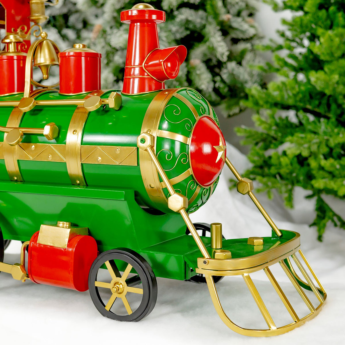 Close-up of the train’s green locomotive, showing its red smokestack, gold bands, wheels and front grille.