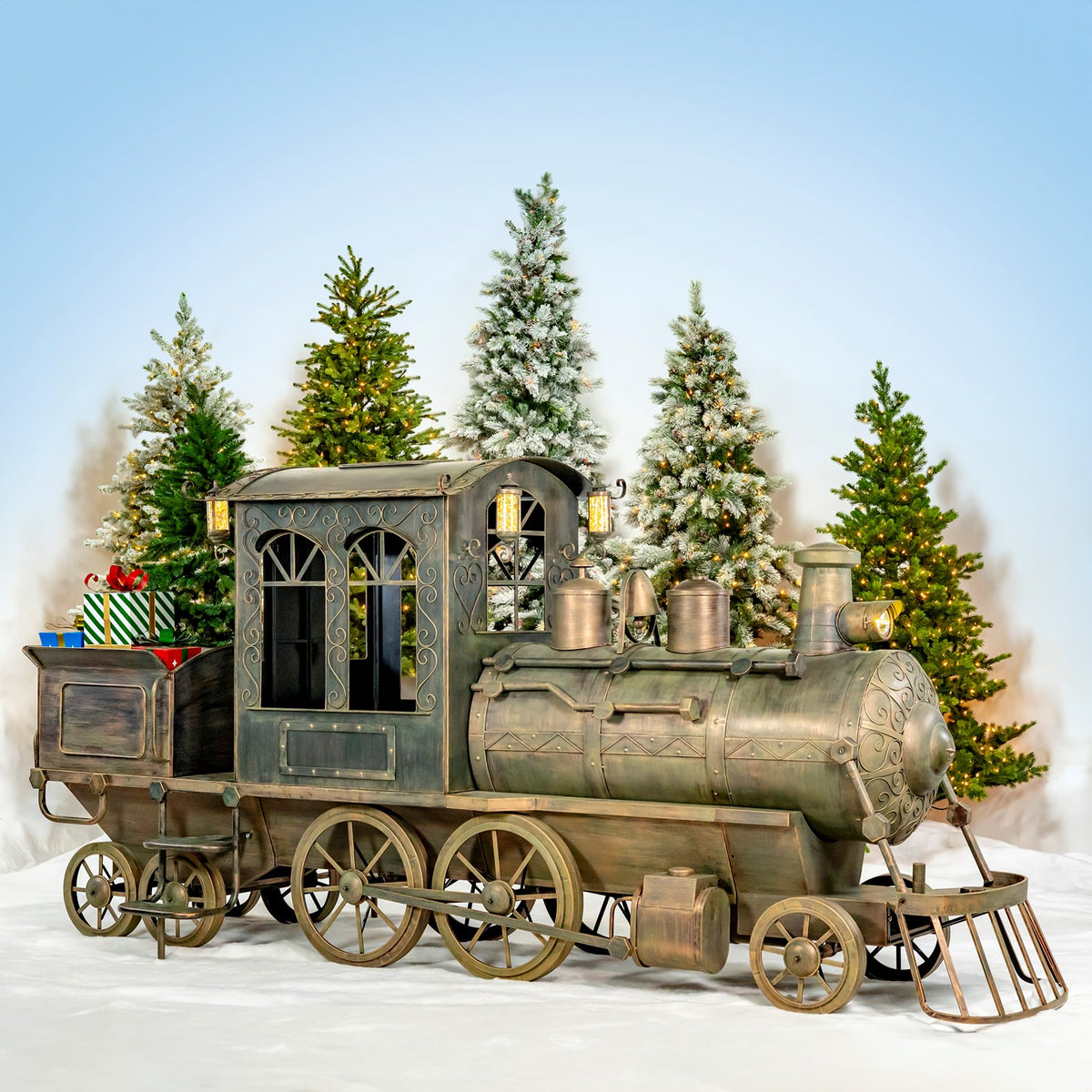 Full side view of a hand-painted iron Christmas train and cart in a snowy scene