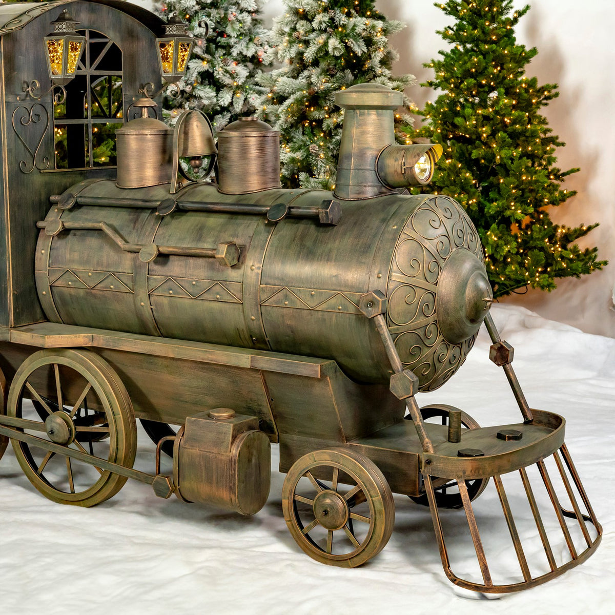 Close-up of the antique bronze locomotive and front wheels in a snowy scene