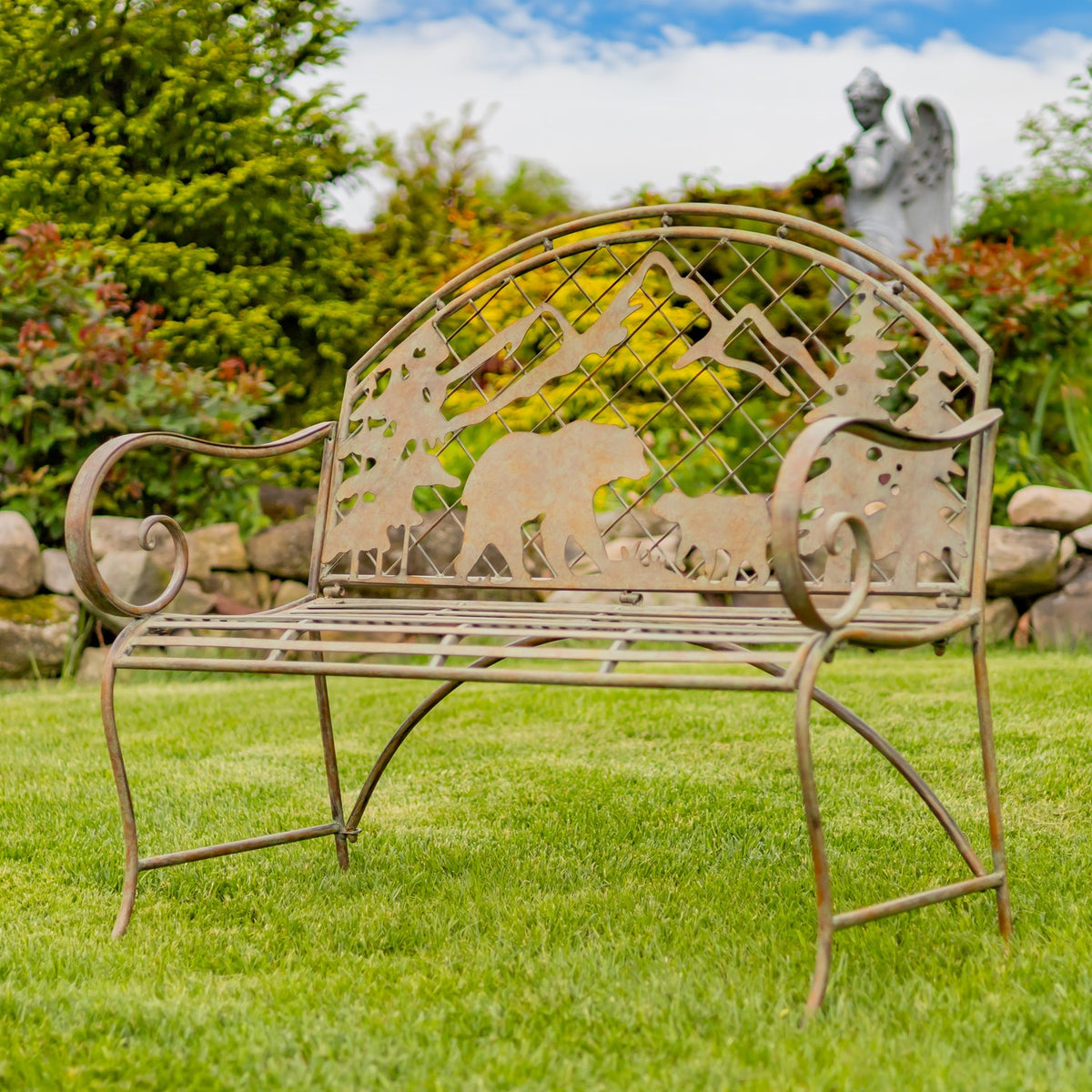 Angled view of an arched metal bench with curled armrests and wildlife silhouettes on the back.