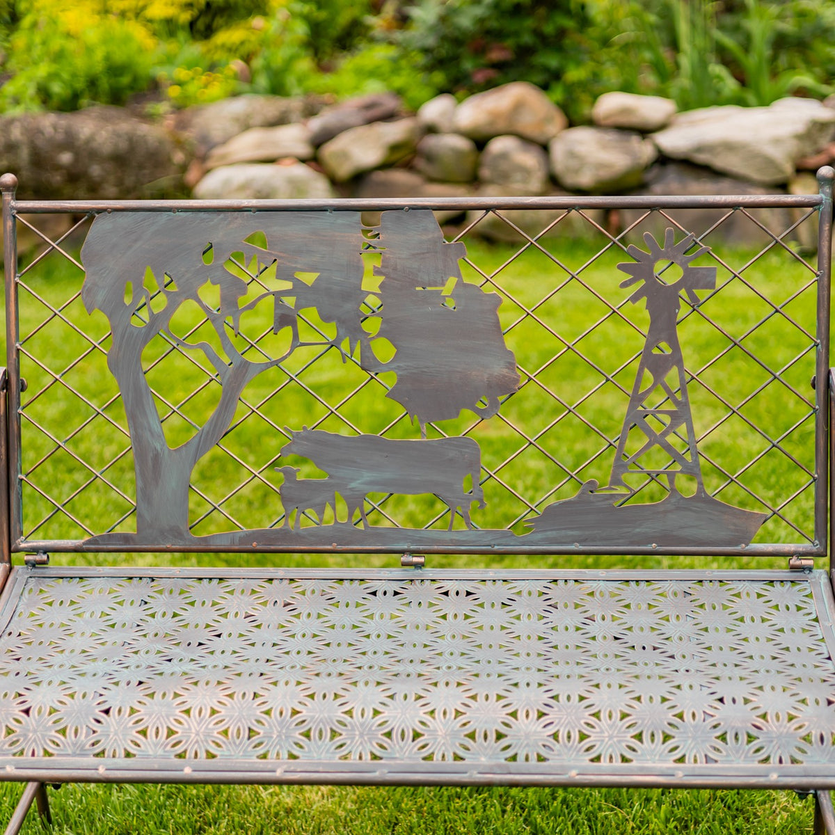 Front-facing view of the bench shows its cutout farm scene, diamond-pattern backrest and patterned metal seat.