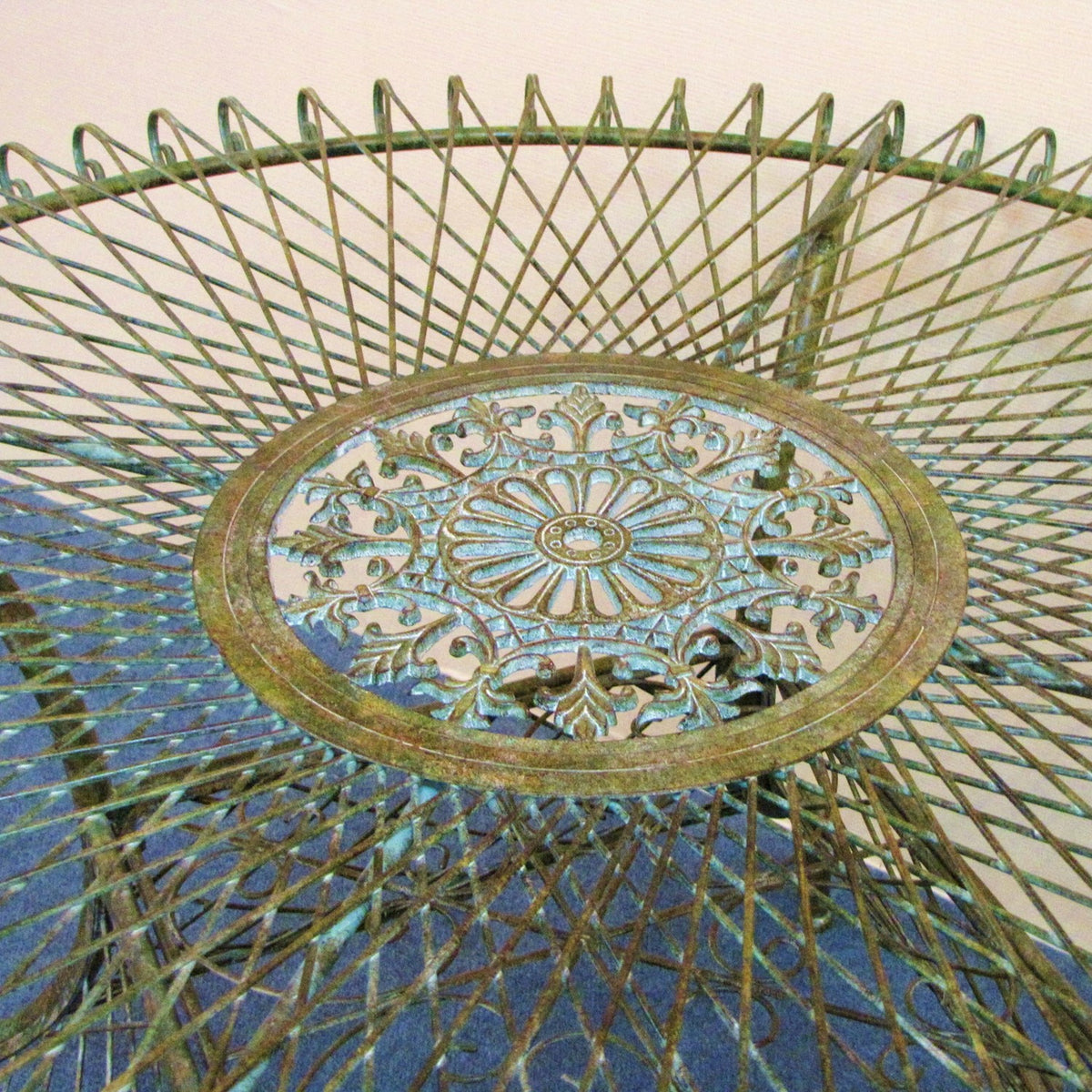 Close-up of the table’s floral medallion and radiating woven ironwork.