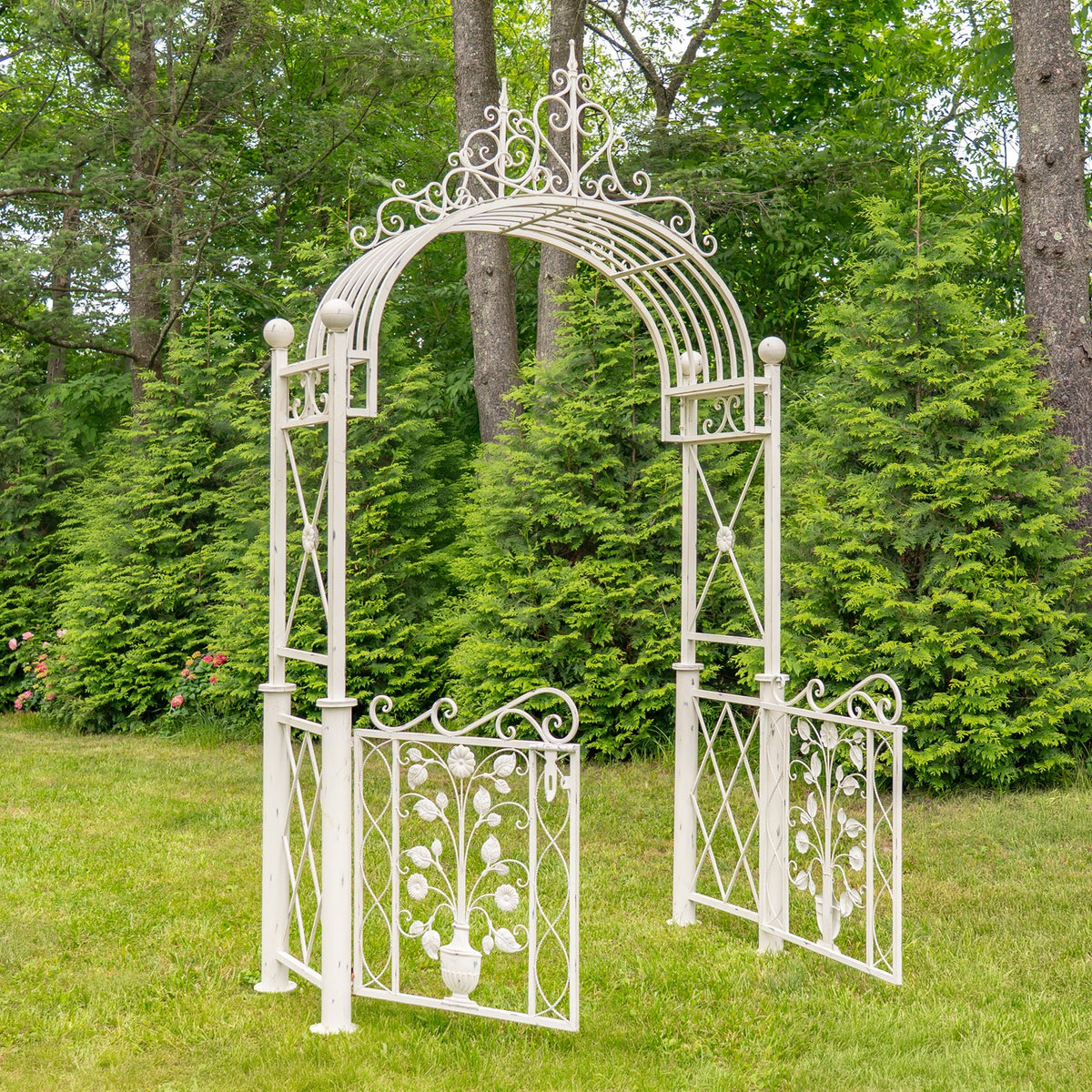 White garden arch with both floral gate panels open outward on the lawn.