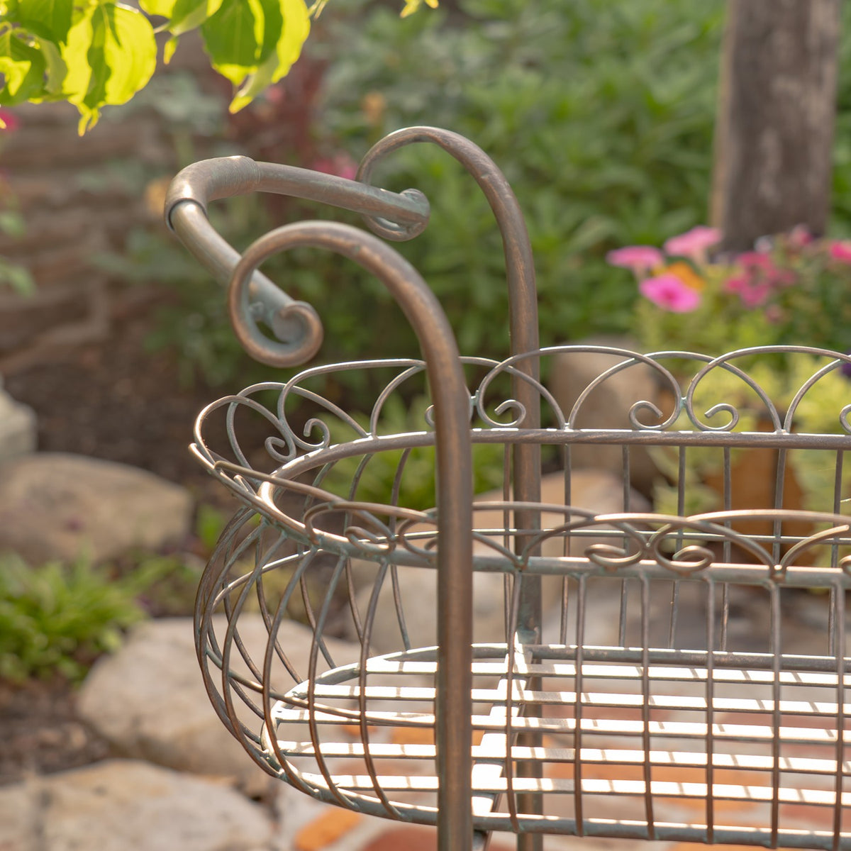Close-up of the stand’s curled handle and ornate wirework around the upper basket.