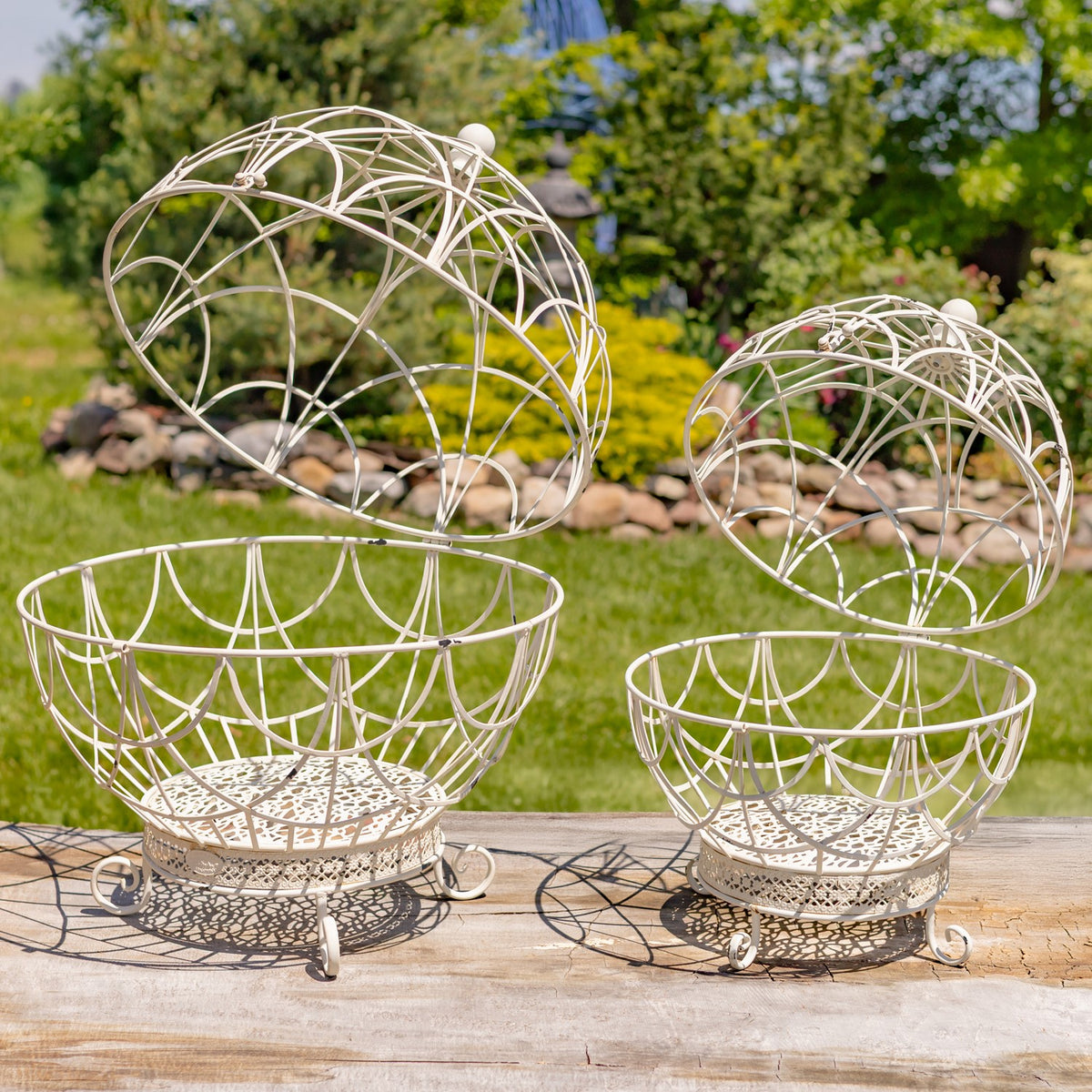 Pair of antique white globe plant stands shown open outdoors