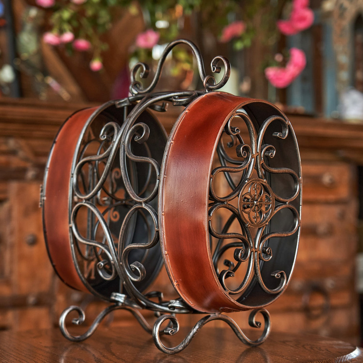 Wine rack viewed from the other side, showing its curled metal frame and decorative circular end.