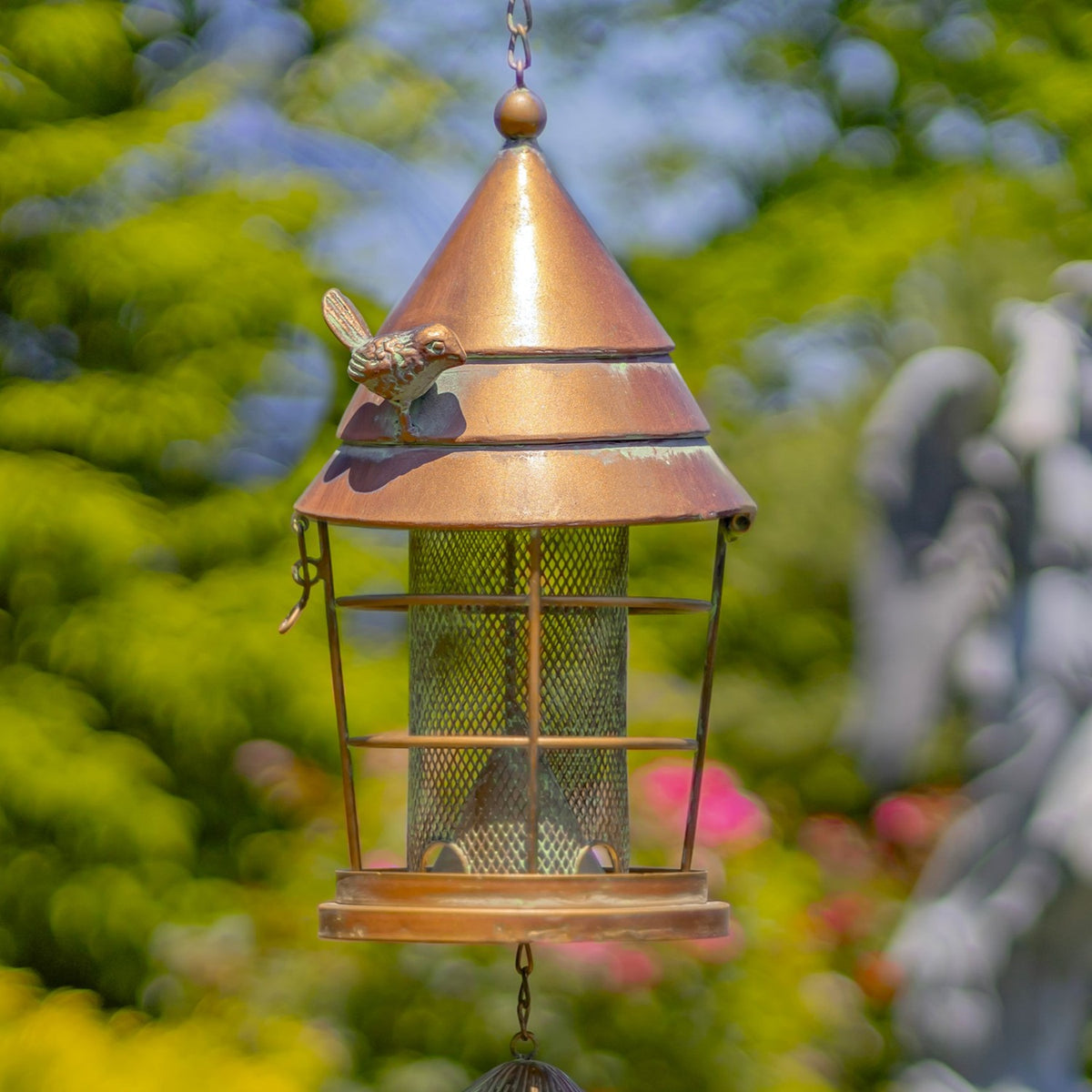 Close view of copper-toned feeder roof, bird accent and mesh seed cylinder