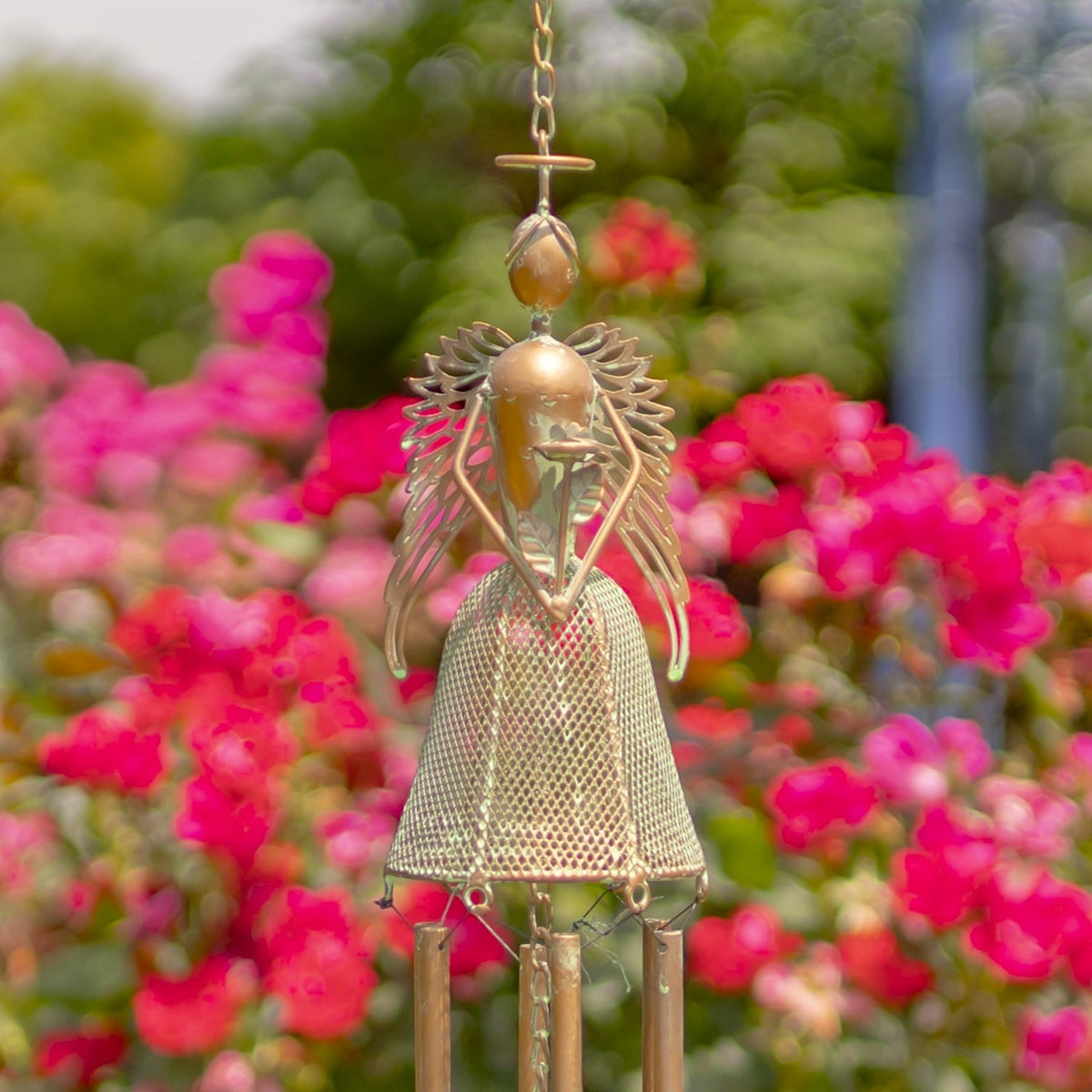 Close view of the angel’s textured dress, outstretched wings, and hanging chime tubes.