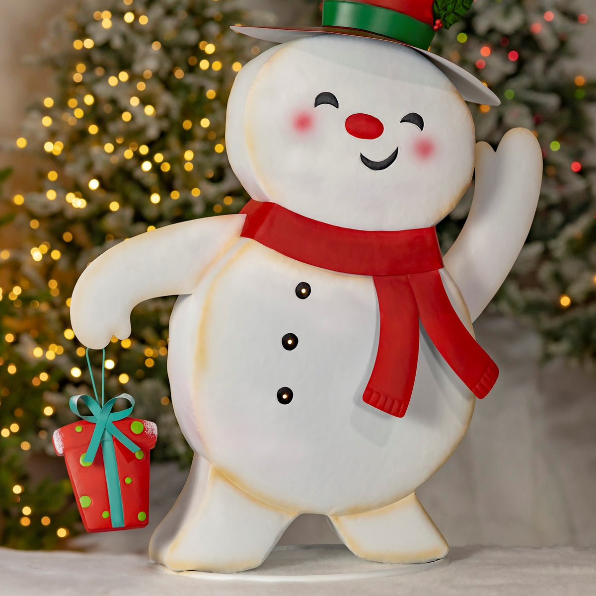 A waving snowman in a red scarf and top hat holds a green-and-red gift.