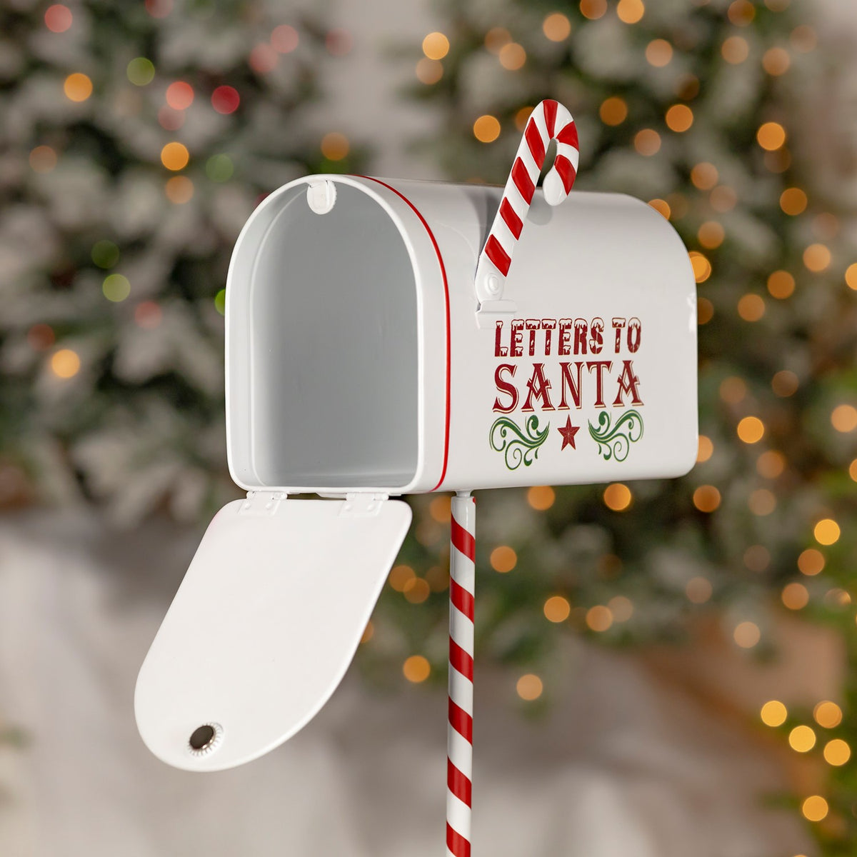 White mailbox with its door open, a candy cane hook, and a red-and-white striped post.