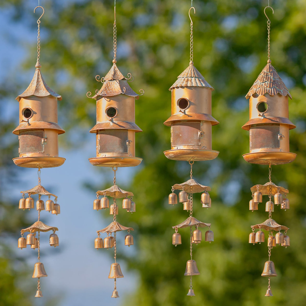 Four hanging birdhouse feeder wind chimes in different roof styles, each with mesh compartments and dangling bells.