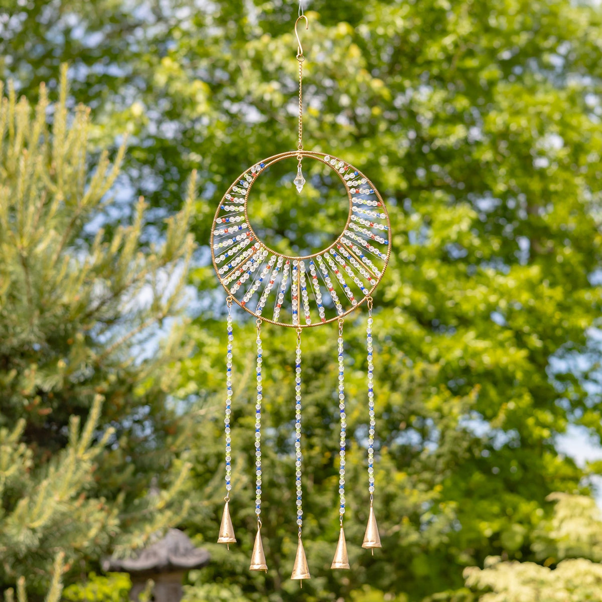 Silver-toned beaded ring chime with four dangling bells hanging among trees