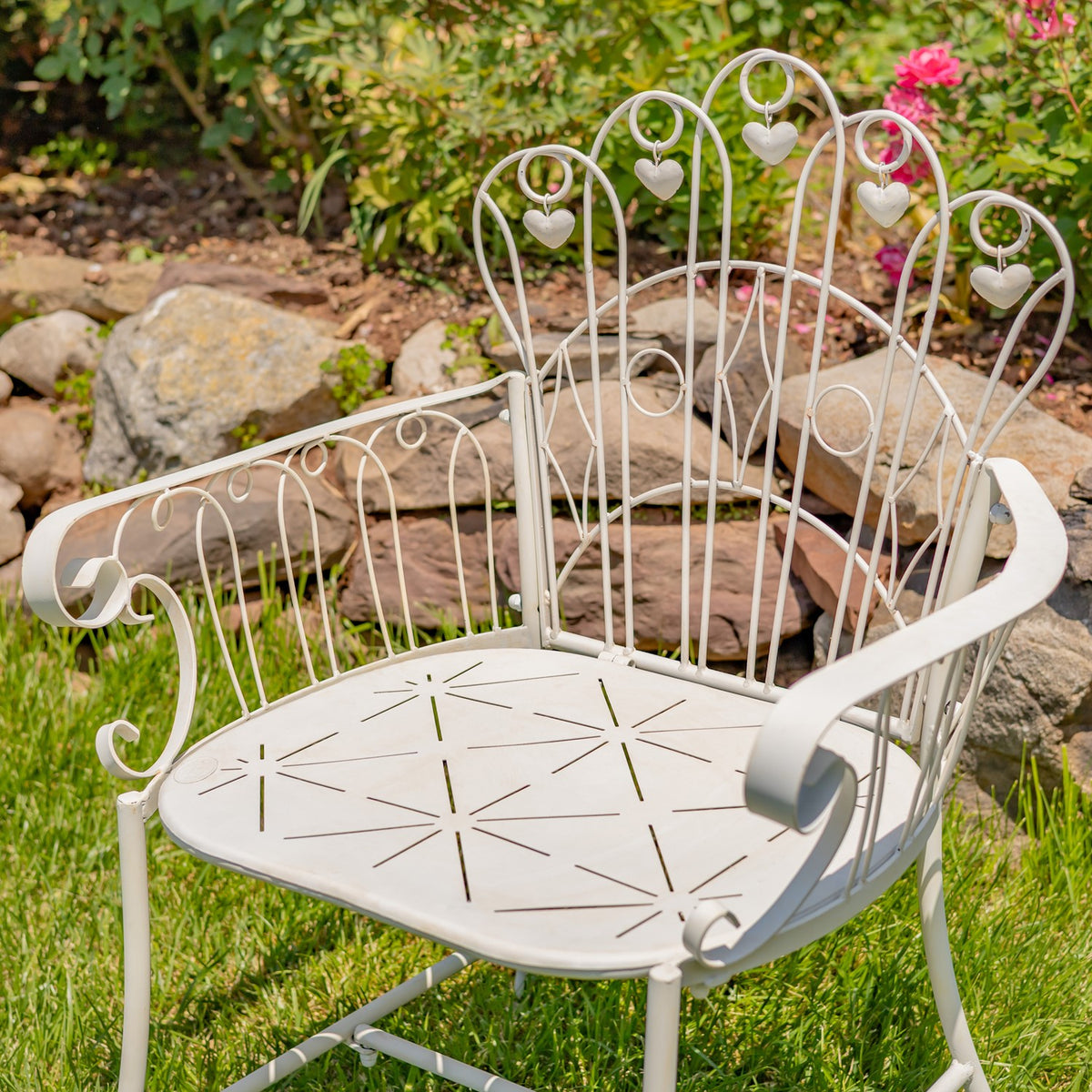 Ivory garden armchair viewed from above, showing its pierced seat and ornate metal back.