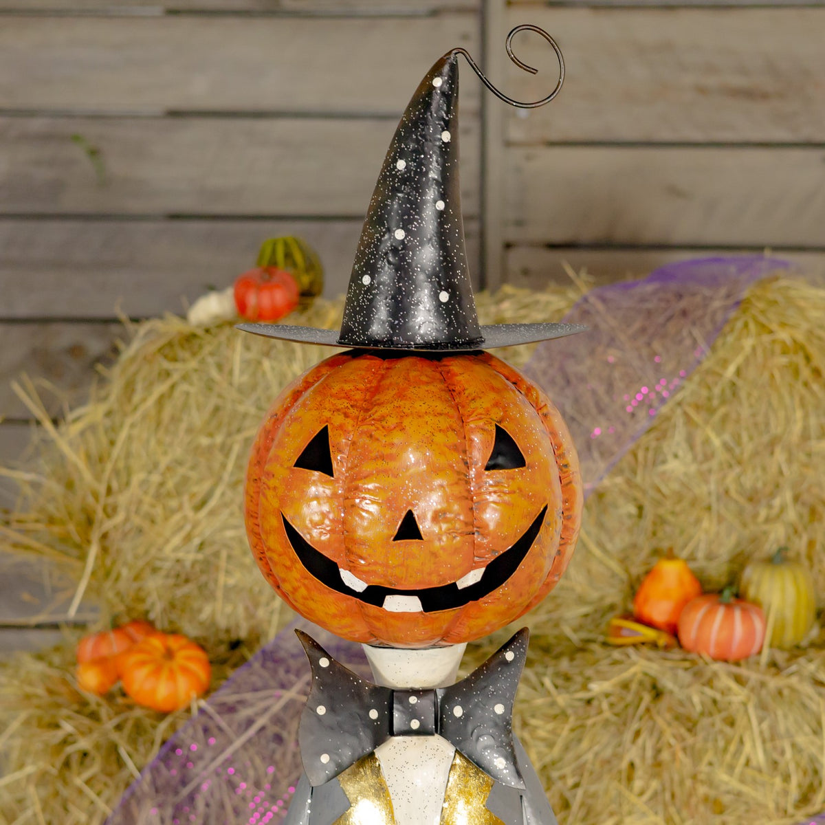 Close view of the orange jack-o'-lantern face beneath a black top hat