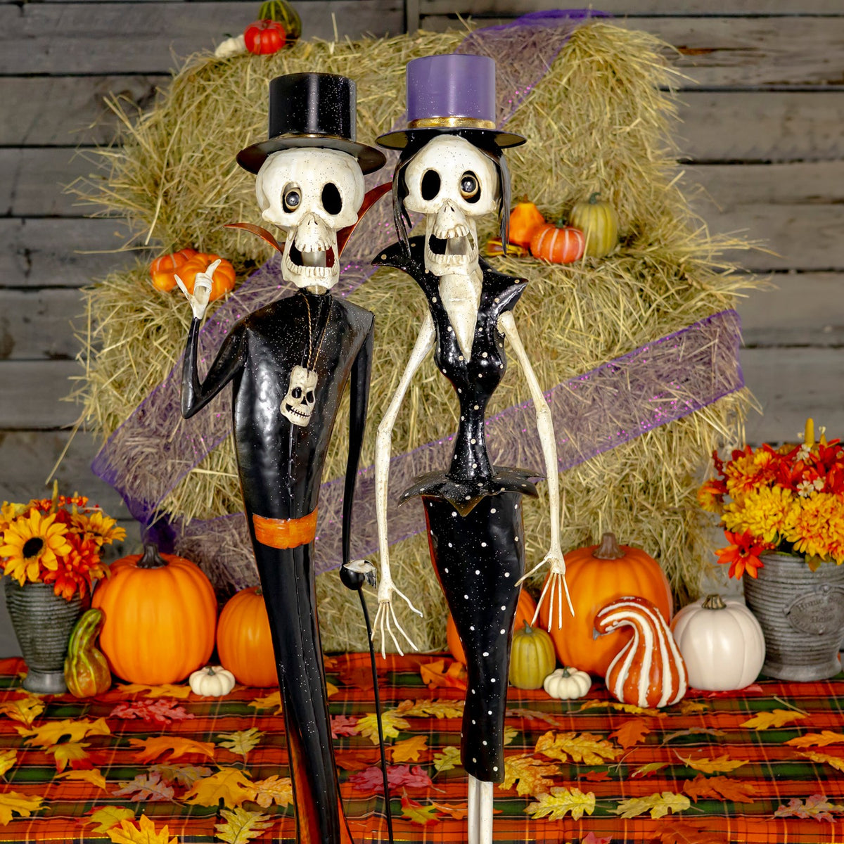 Closer view of two skeleton figurines in black outfits and top hats