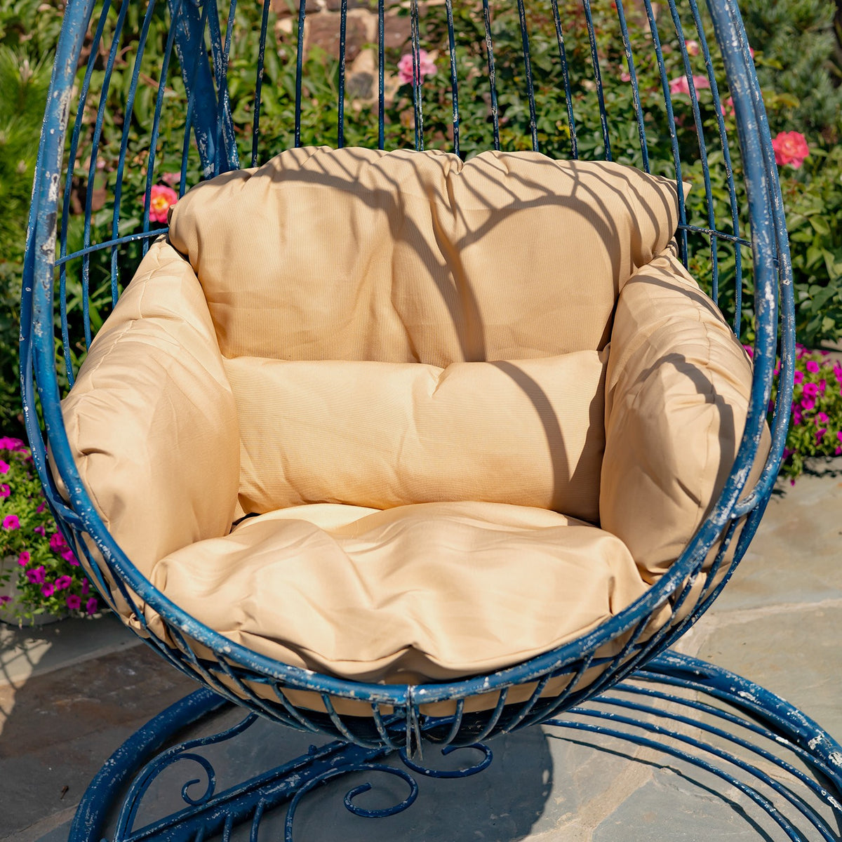 Close view of the tan padded seat and back inside the blue metal chair.