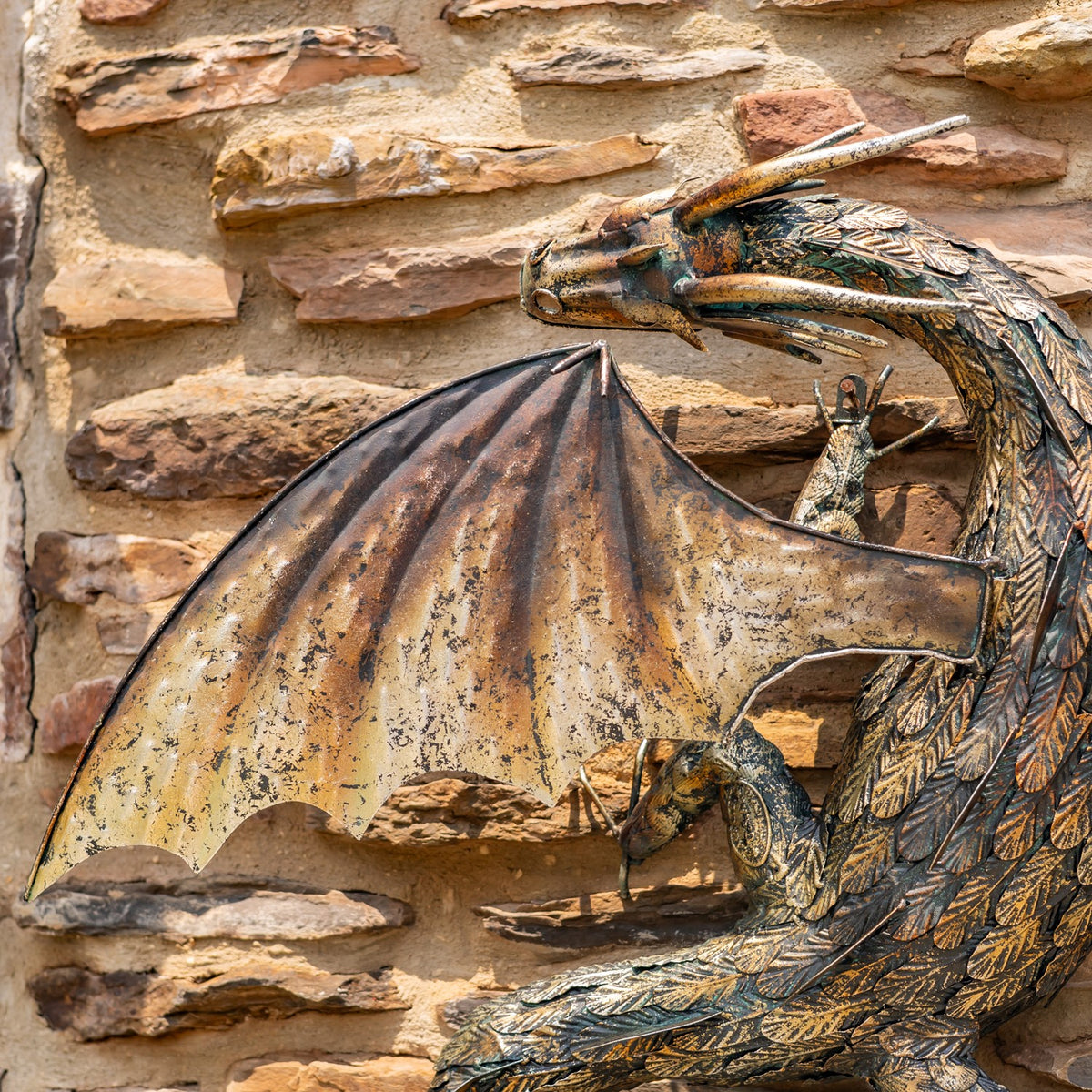 Close view of the dragon’s horned head, textured scales and broad left wing.