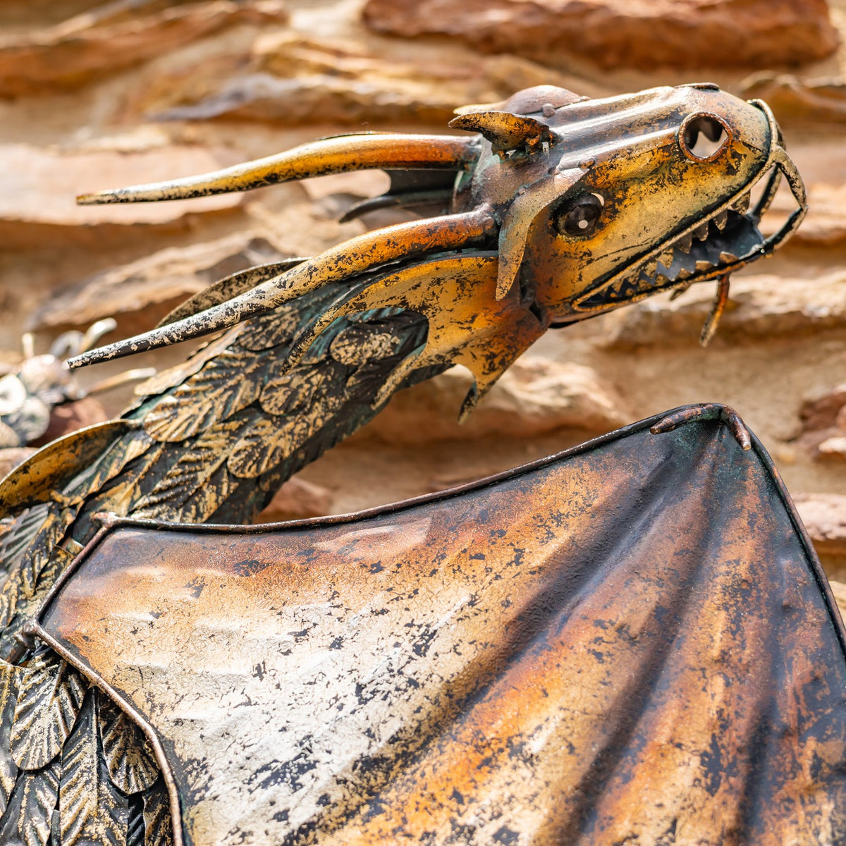 Close-up of the dragon’s long snout, open mouth, textured neck, and mottled wing.
