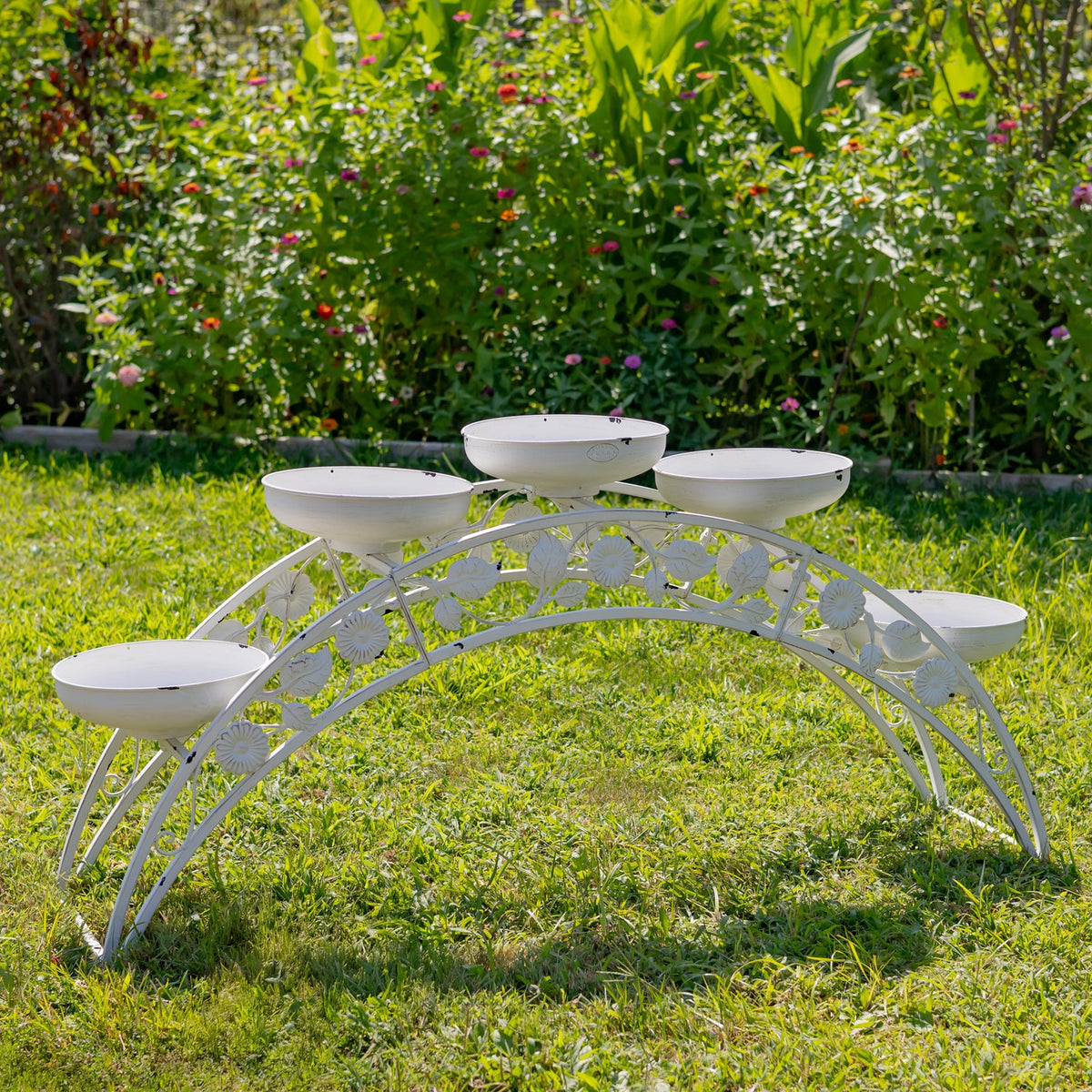 White arched metal stand with five shallow planter bowls spaced along the top