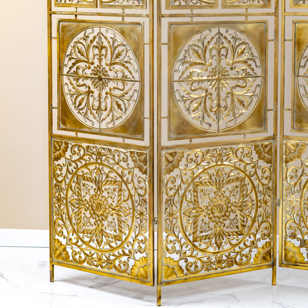 Close view of the screen’s gold floral medallions and hinged panels, with a reflective backing.
