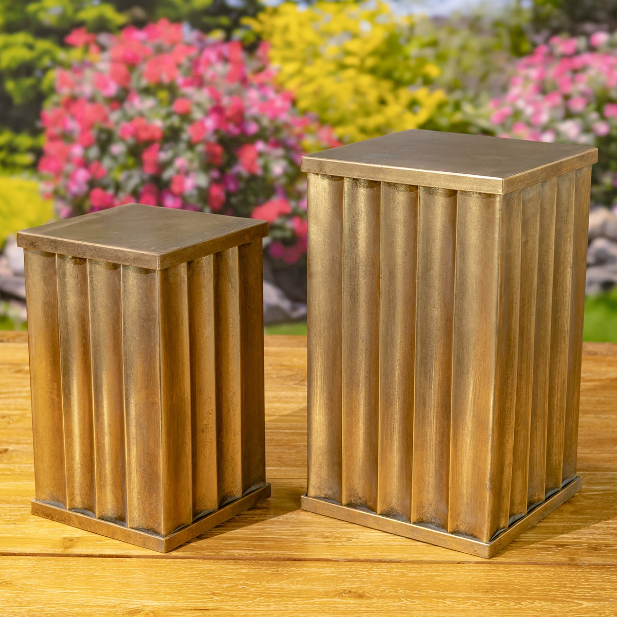 Two empty gold-toned pillars of different heights with fluted sides and flat square tops.