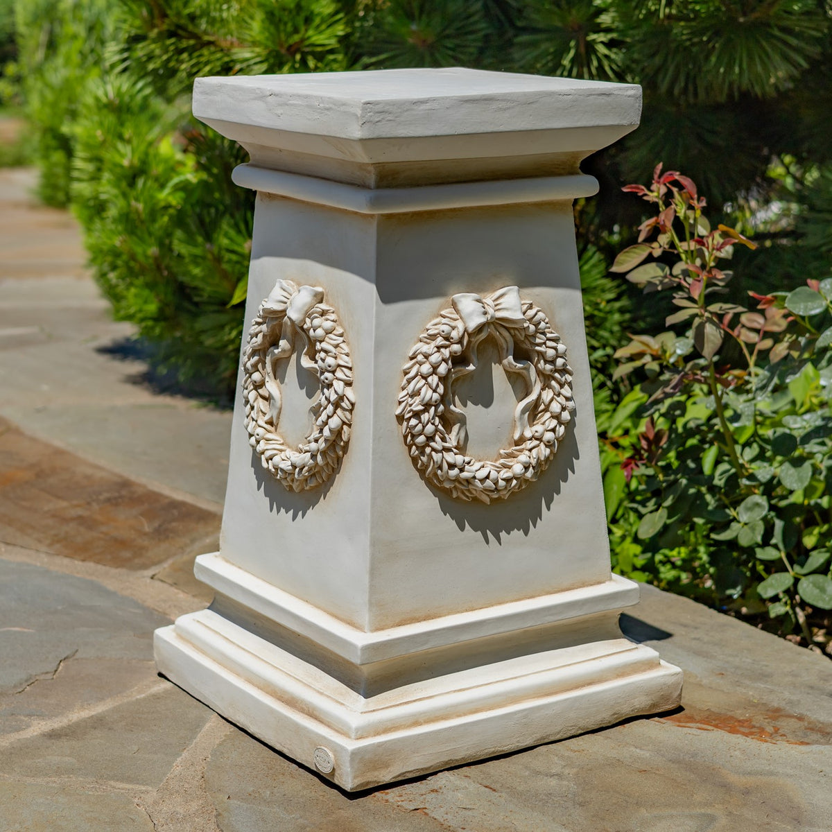 Light-colored column shown without a flowerpot, with two raised wreath ornaments on its sides.