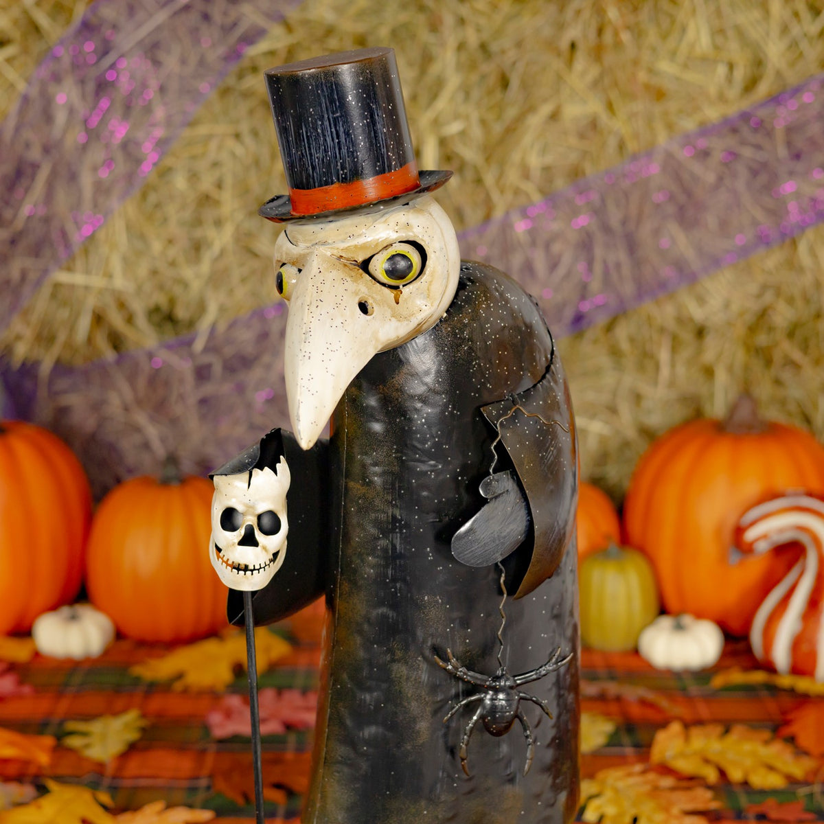 Close-up of the vulture figurine's top hat, beak, and skull ornament